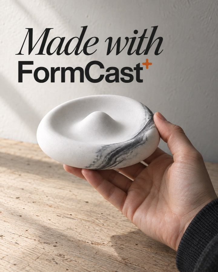 A marbled cast dish held in one hand
