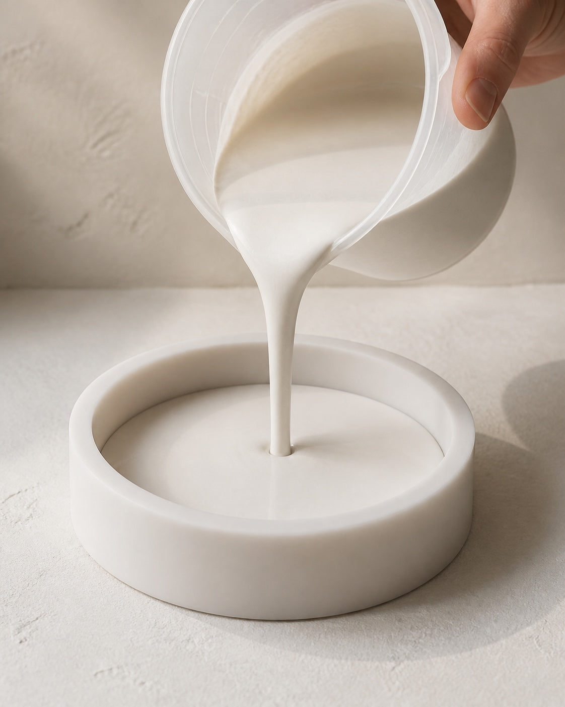 FormCast being poured from a measuring cup into a round silicone mould