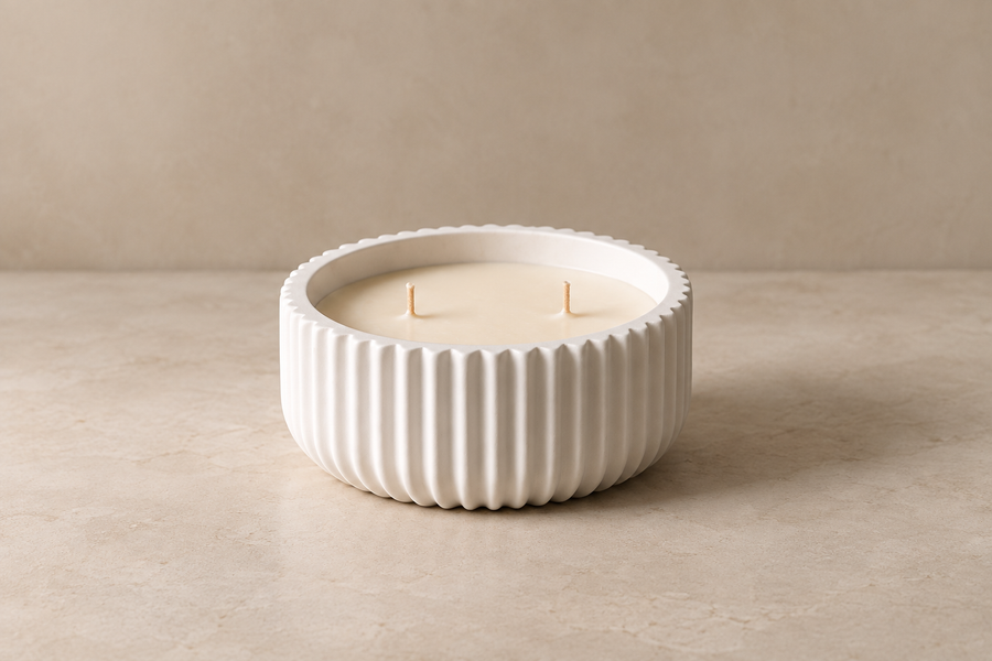 White ribbed candle vessel holding an unlit two-wick candle